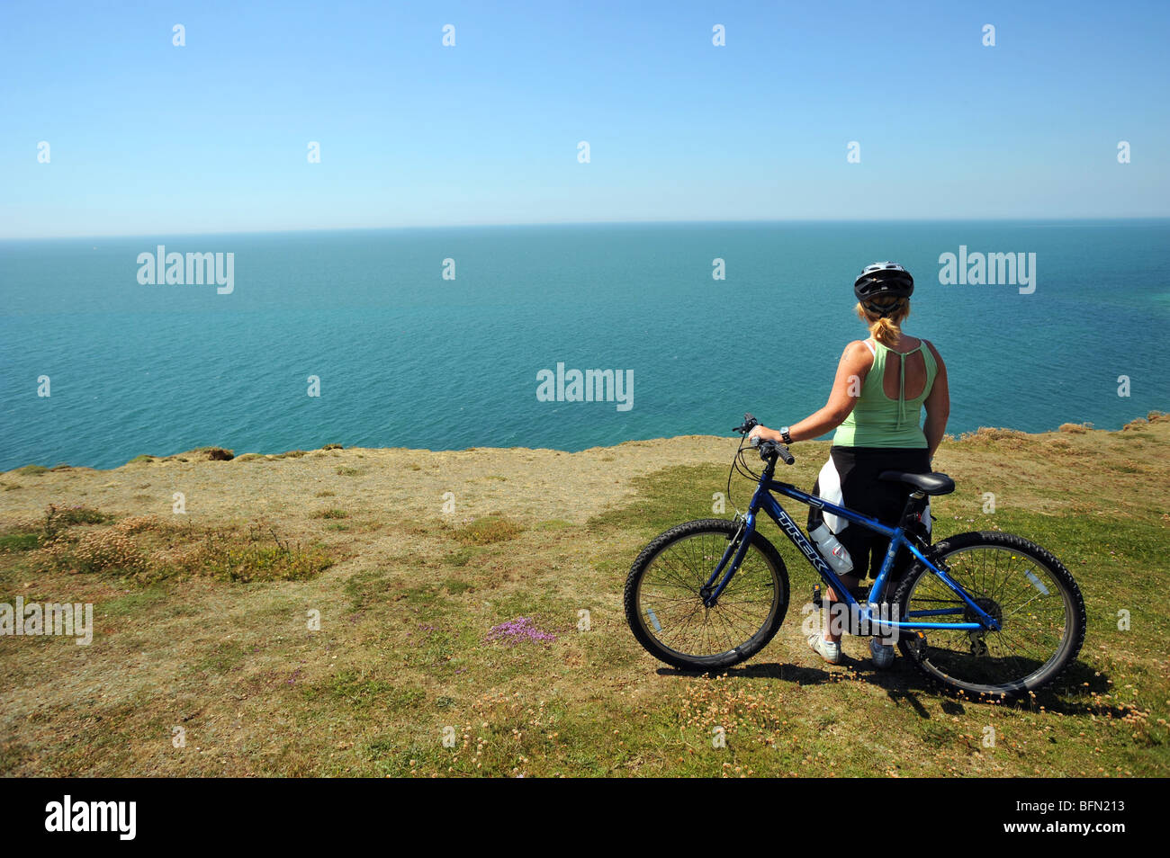 Ein weibliche Radfahrer stoppt, um den Blick von den Klippen bei Peacehaven genießen Stockfoto
