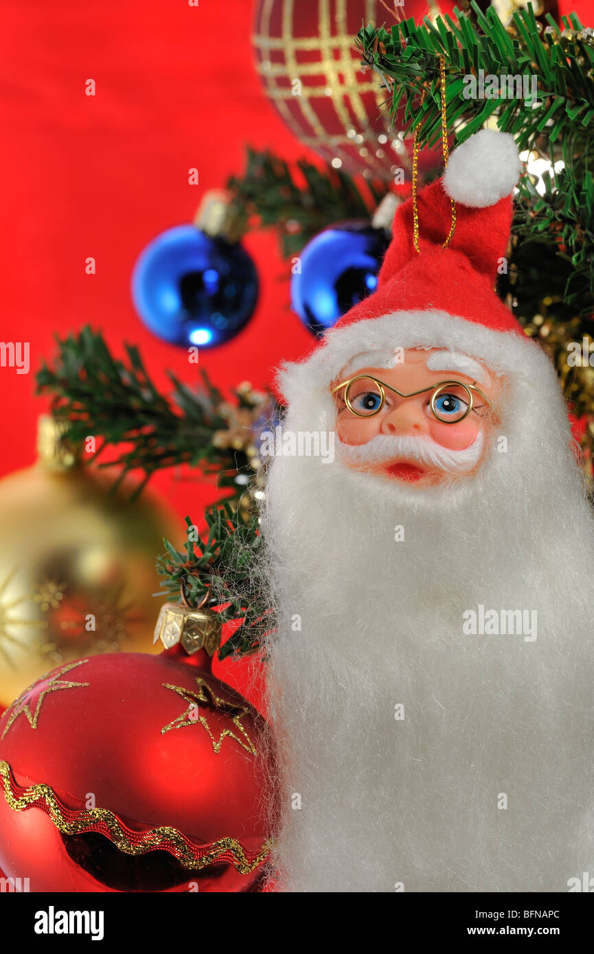 Santa Claus / Weihnachtsmann und Glocken hängen im Baum Stockfoto