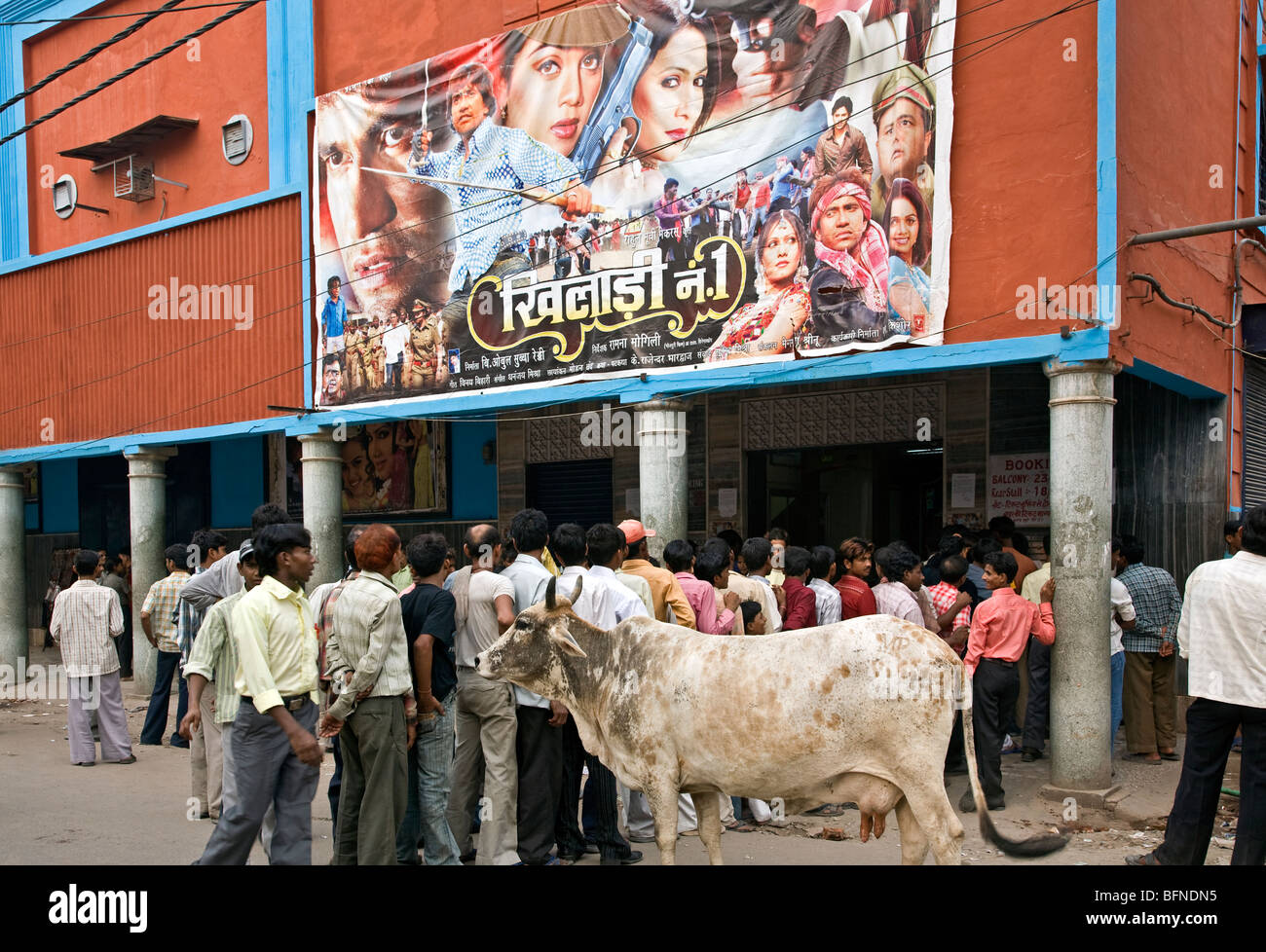 Männer (und Kuh) warten auf die Matinée zeigen. Kaiserlichen Kino. Paharganj. Neu-Delhi. Indien Stockfoto