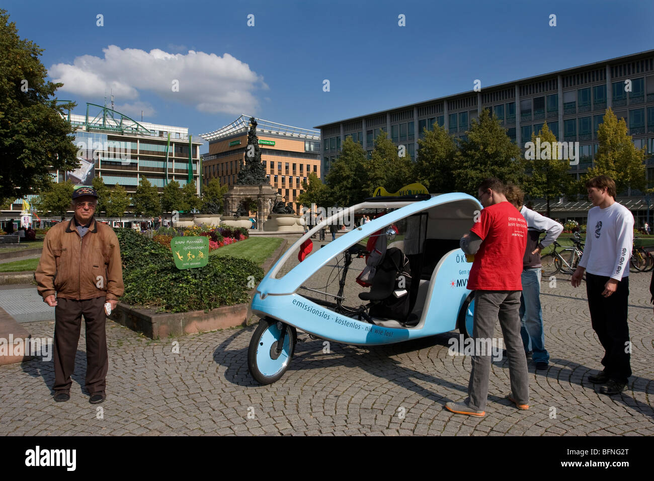 Potenzielle Fahrgäste bewundern einen Zyklus Rikscha Taxi in Mannheim, Deutschland Stockfoto