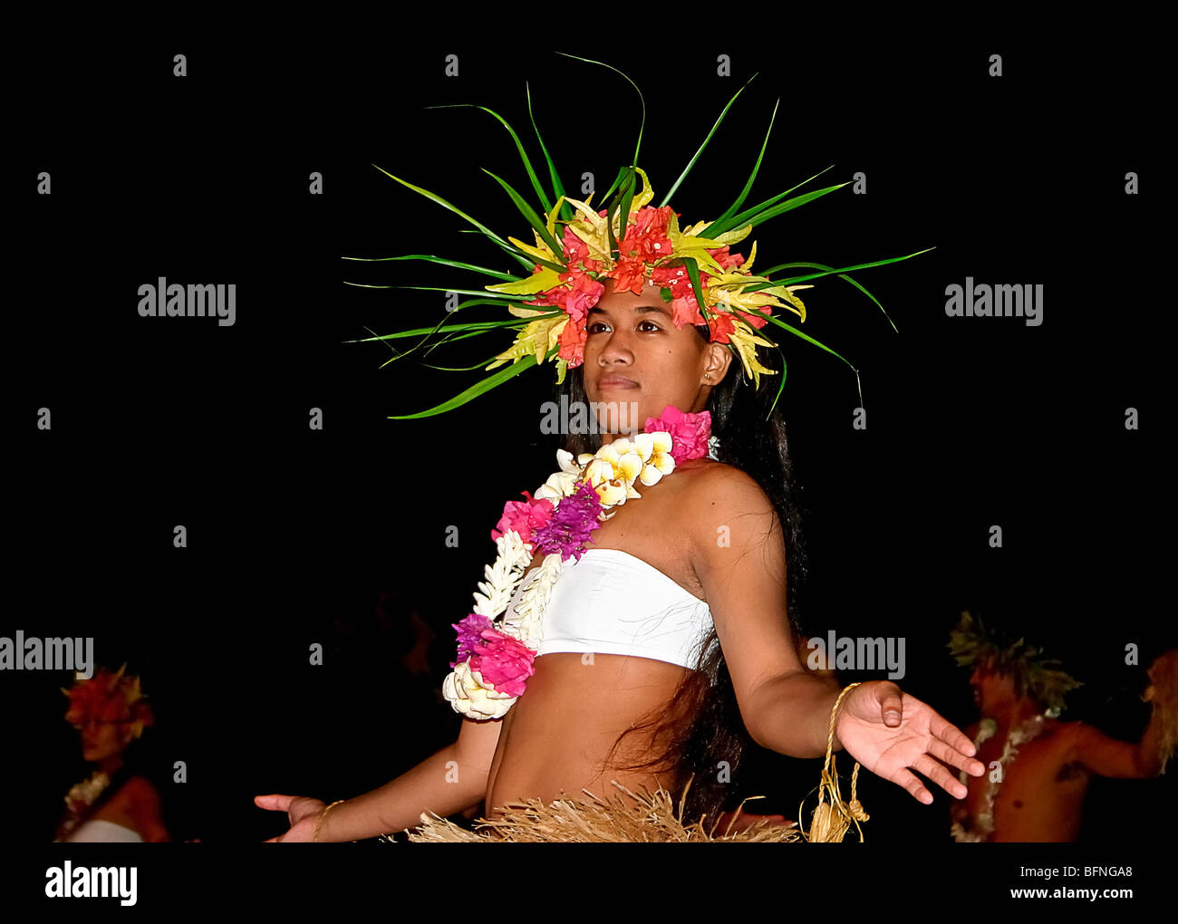 Einheimischen Mädchen mit Blumen in ihrem Haar und gekleidet in Grass führt Rock Tahiti Tanz während der Show, Moorea, Tahiti Stockfoto