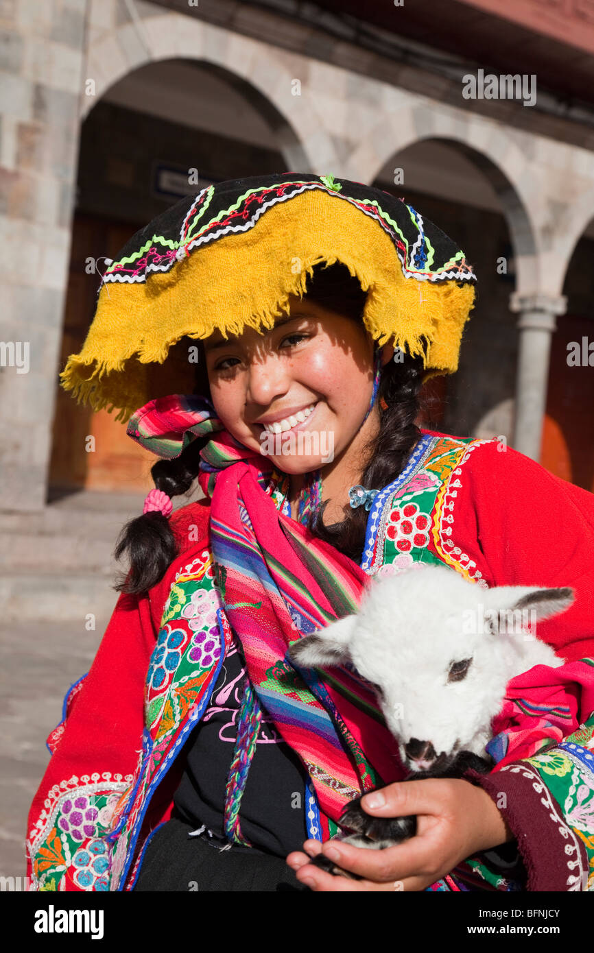 Hübsches peruanische Mädchen in traditioneller Tracht mit Lamm in Plaza de Armas, Cuzco, Peru Stockfoto