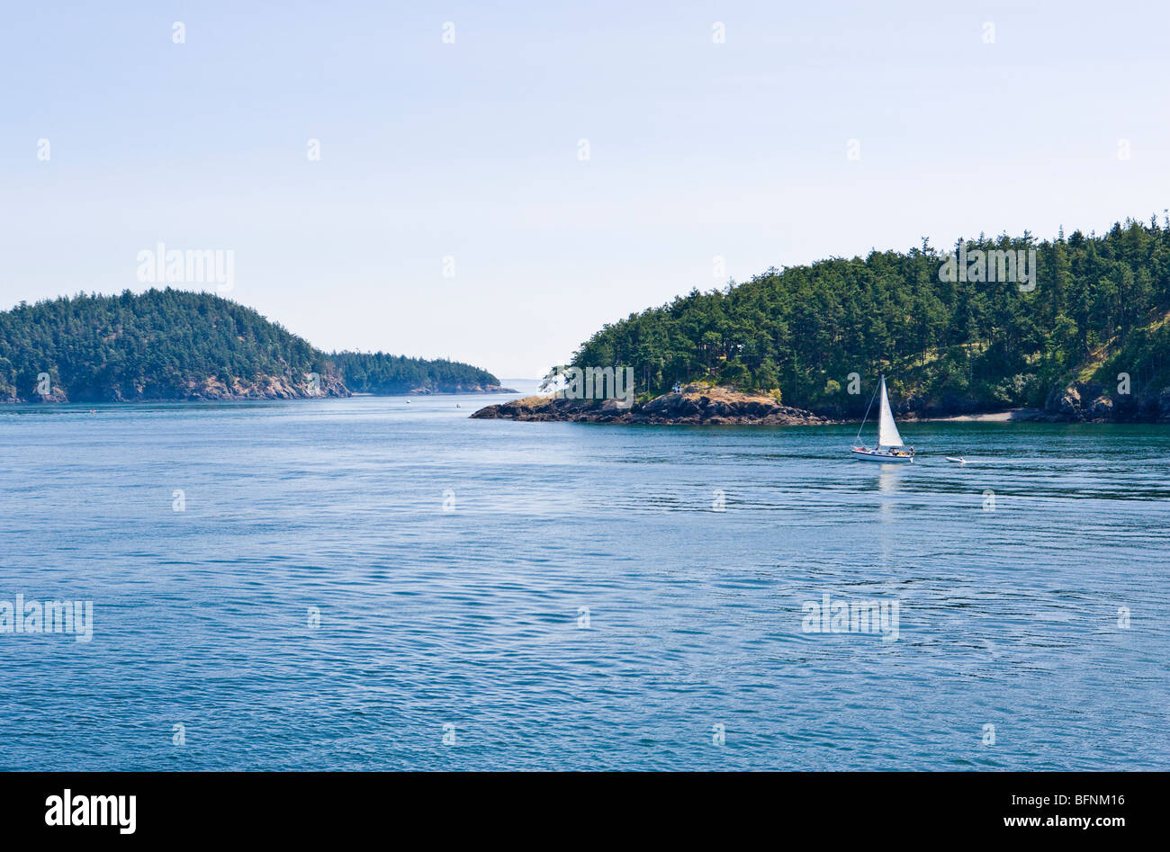 Ein Segelboot segeln in einem Kanal zwischen den Inseln in den San Juan Islands, Washington, USA. Stockfoto