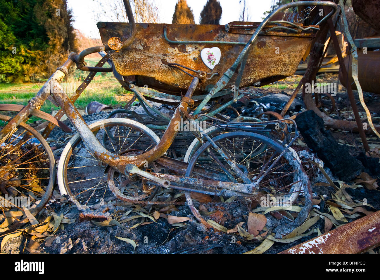 Kinderfahrräder und ein Puppen-Kinderwagen durch einen Wald zerstört Feuer. Stockfoto