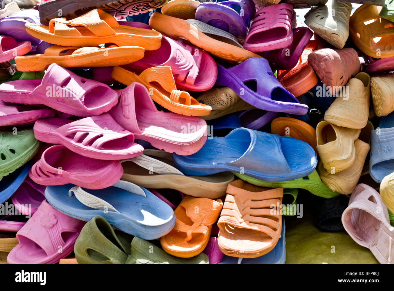 Ein Stapel von bunten Kunststoff-Sandalen in einem Markt zu verkaufen Stockfoto