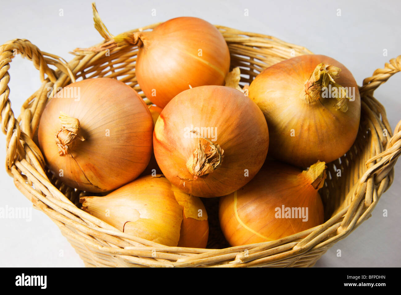 Korb mit Zwiebeln auf einem weißen Hintergrund Stockfoto