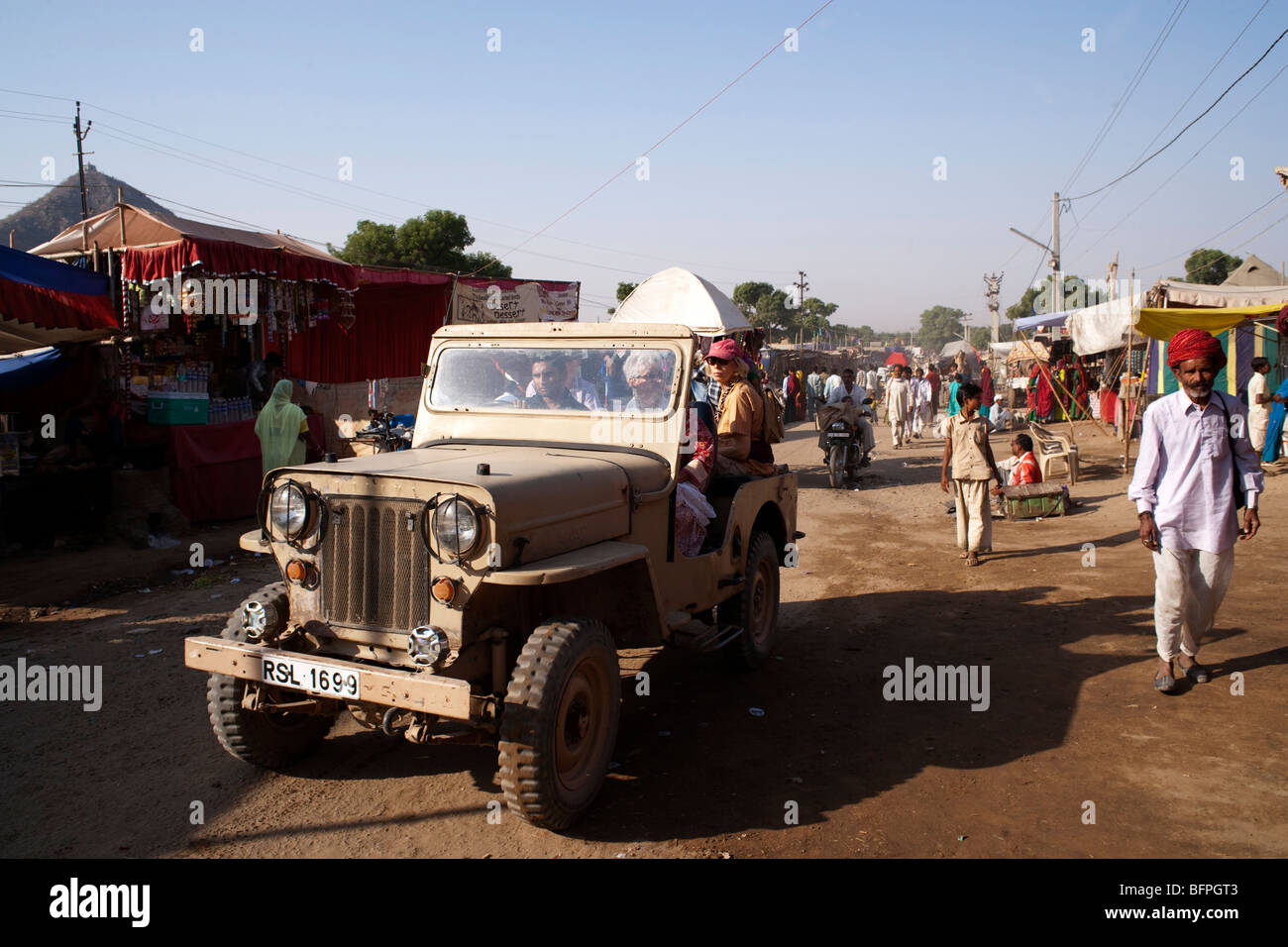 Ausländische Touristen in einem Jeep nehmen Fahrt auf Pushkar fair, Rajasthan Indien. Stockfoto