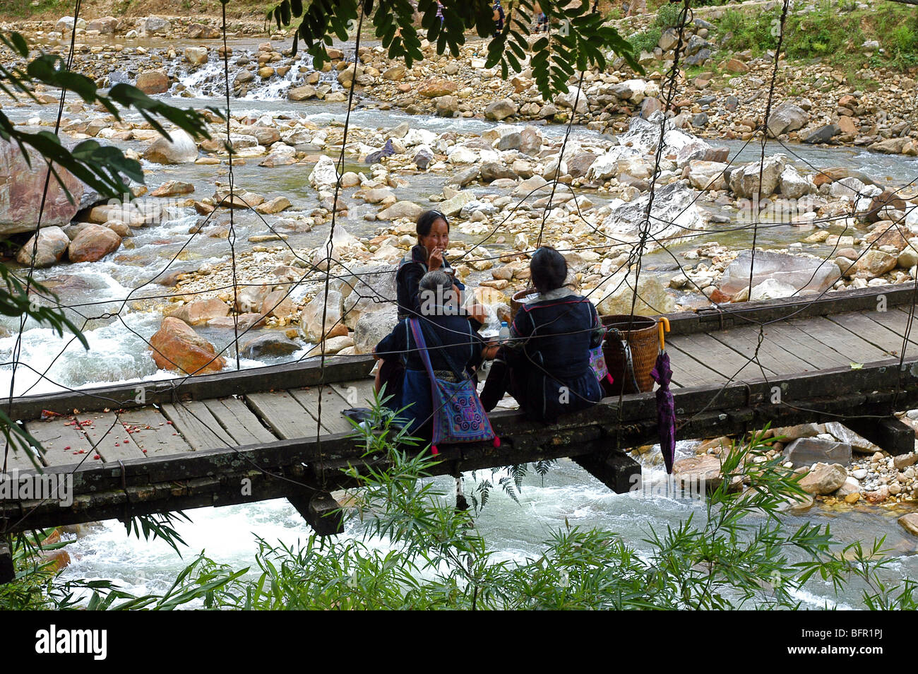 Einheimische Frauen in Stammes-Kleid mit Mittagessen auf einer Brücke in der Nähe von Sa Pa, eine Stadt im Nordwesten Vietnam Stockfoto