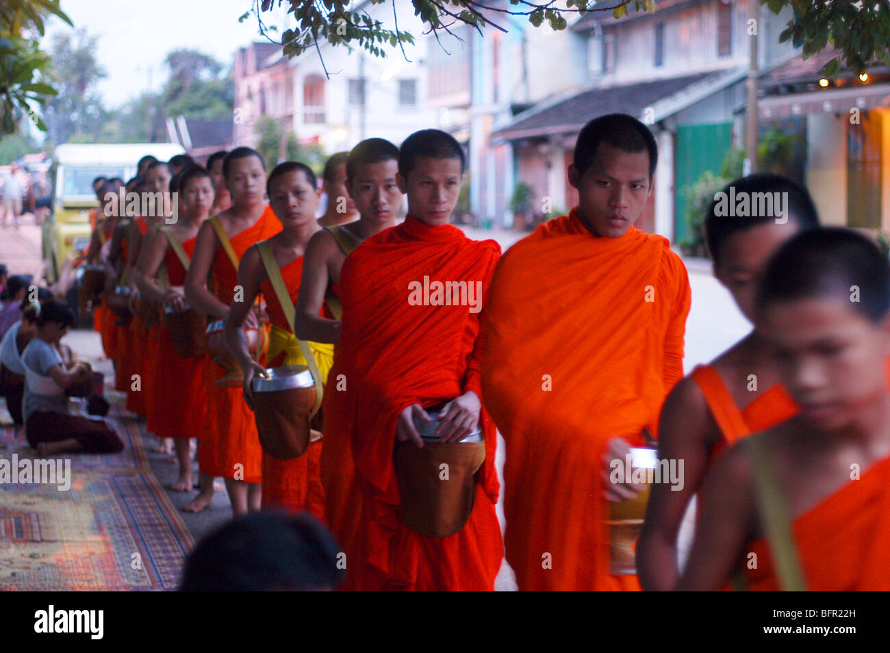 Buddhistischen Mönchen Almosen im Morgengrauen in die Stadt Luang Prabang, der alten laotischen Hauptstadt Stockfoto