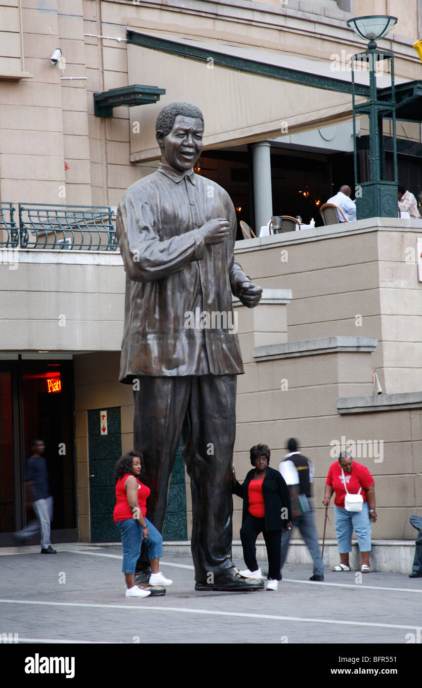 Touristen posiert neben einer Statue von Nelson Mandela in Mandela Square in Sandton Stockfoto
