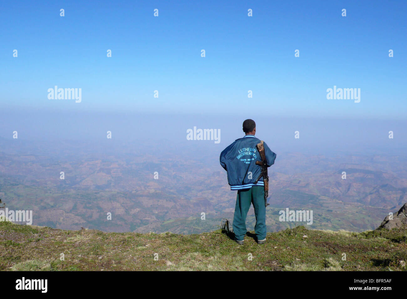 Einem lokalen Führer mit einem Gewehr über der Schulter mit Blick auf die Hügel und Täler unten in den Simien-Bergen Stockfoto