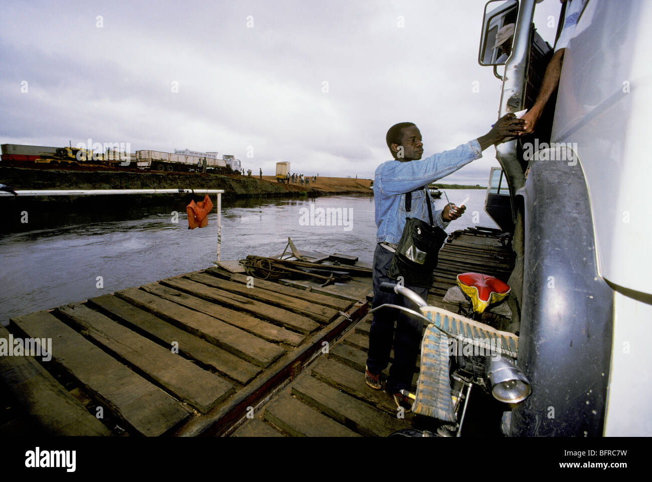 Angestellter am Zambezi River ferry Übergabe Ticket für LKW-Fahrer. Stockfoto