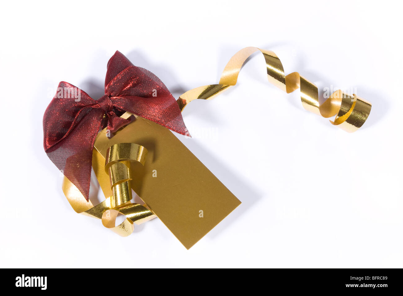 Leere gold Geschenkanhänger mit roter Schleife und goldene Bänder Hintergrundbild über weiß. Stockfoto