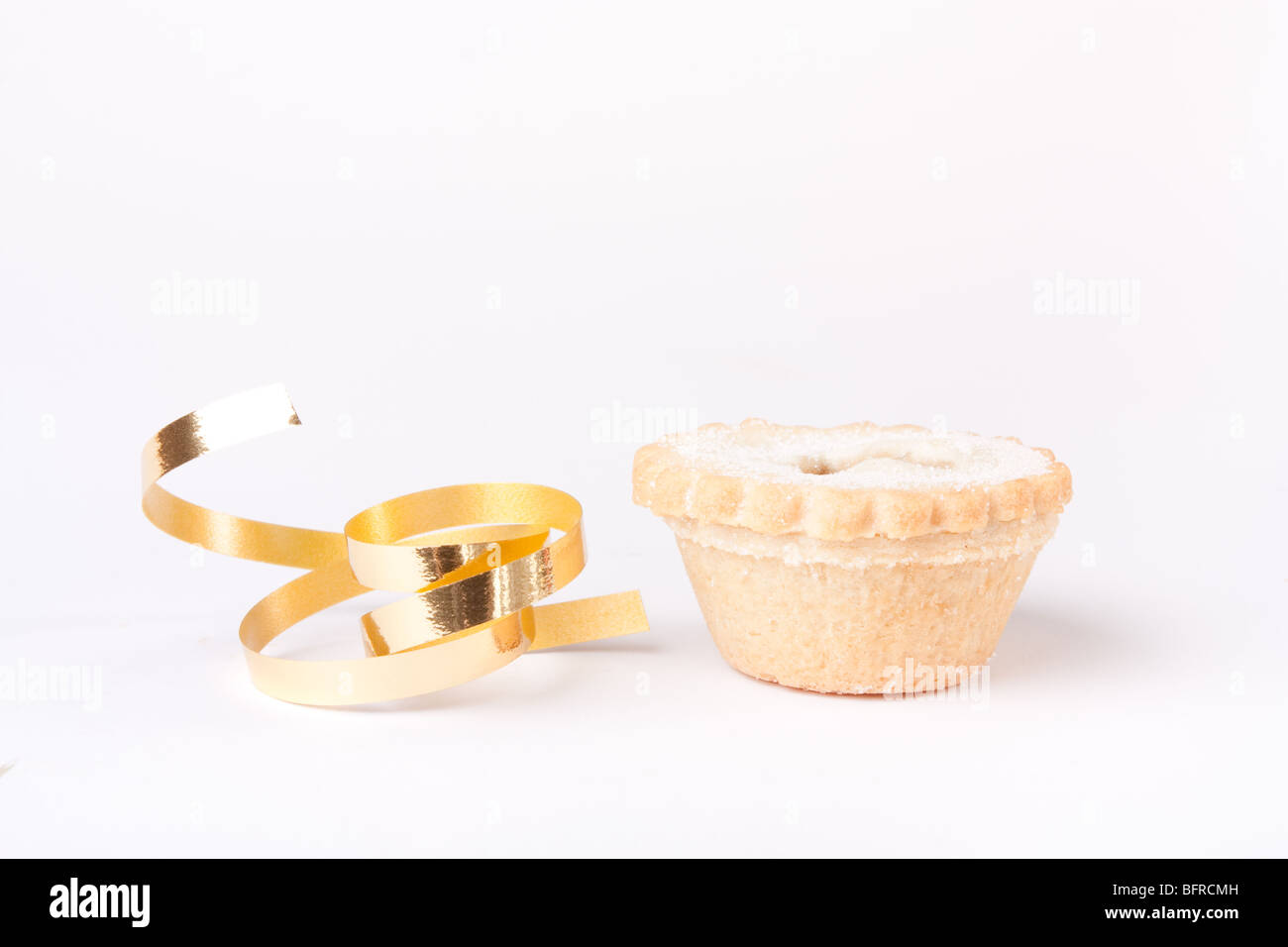 Einzelne Sweet Mince Pie vor weißem Hintergrund mit Goldband isoliert. Stockfoto