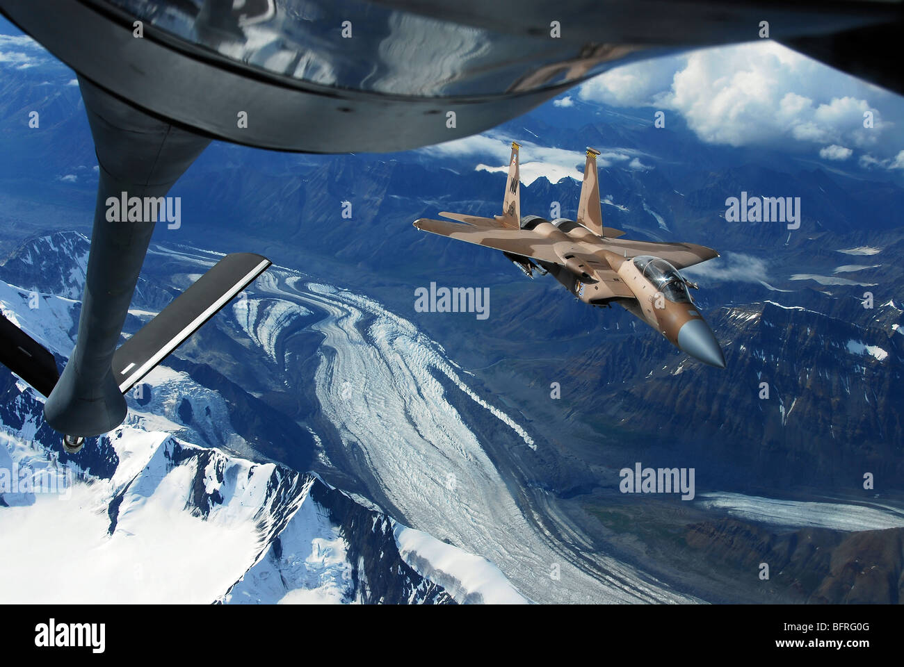 Ein US-Air Force F - 15C Eagle positioniert sich hinter einer KC-135R Stratotanker über Alaska. Stockfoto