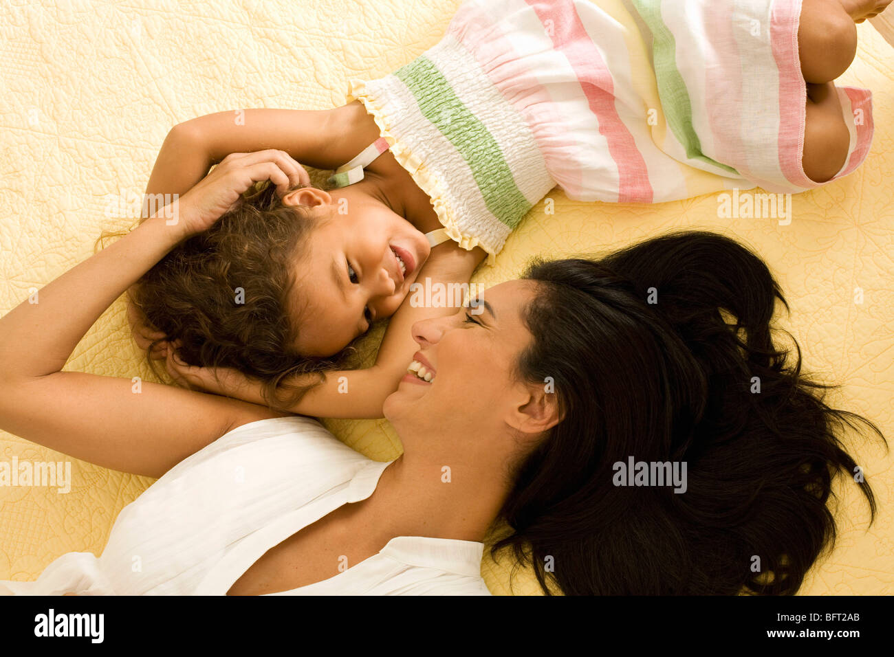 Mutter und Tochter gemeinsam auf Bett liegend Stockfoto