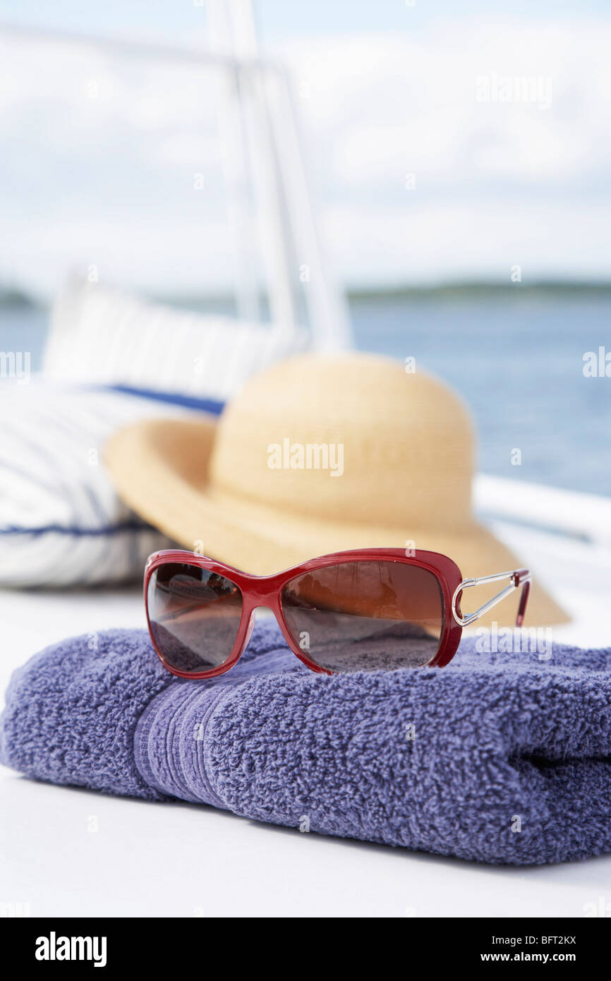 Nahaufnahme von Handtuch und Sonnenbrille auf Boot Stockfoto