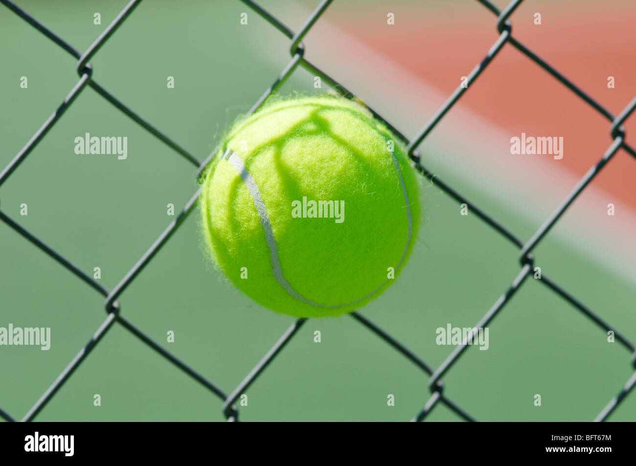 Tennisball in Maschendrahtzaun stecken Stockfoto