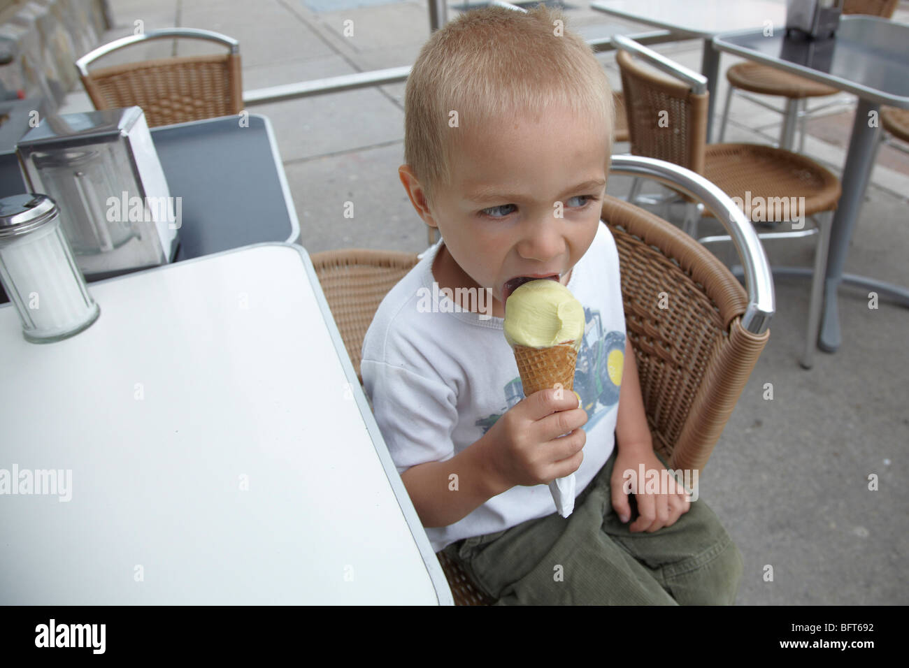Kleiner Junge Eis essen auf der Terrasse des Restaurants Stockfoto