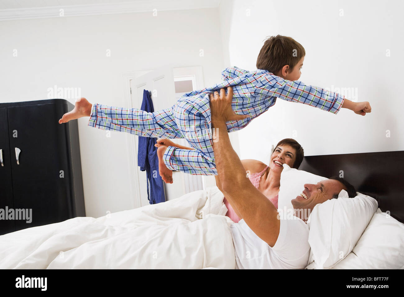 Familie spielt im Bett Stockfoto