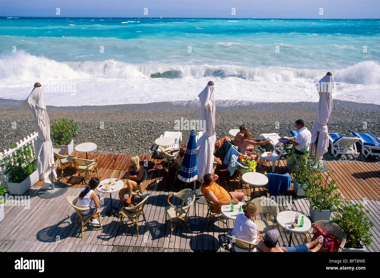 Menschen, die am Strand vor rauer See entspannen Stockfoto