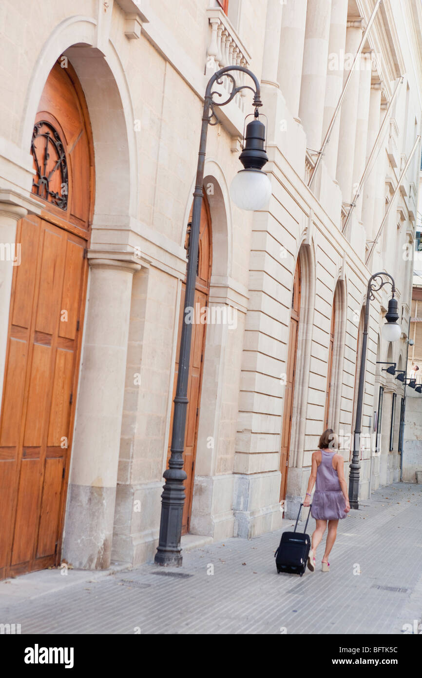 Frau mit Trolly Straße entlang Stockfoto