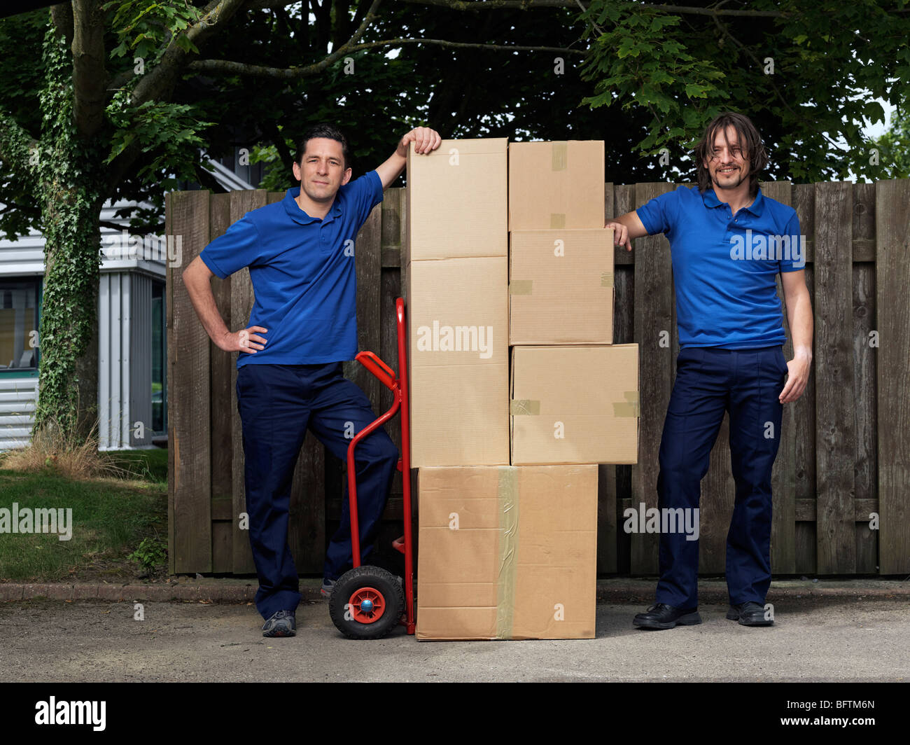 zwei Männer, die Bereitstellung von Boxen auf Wagen Stockfoto