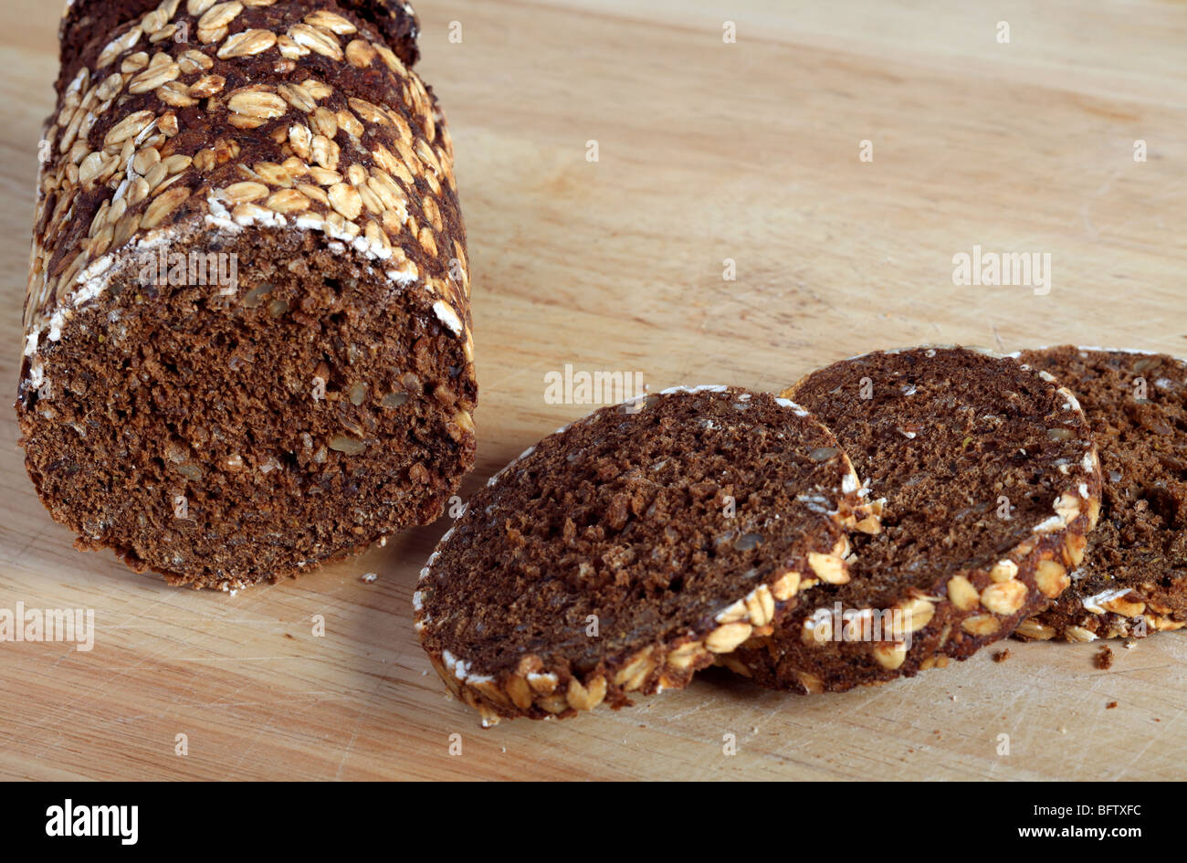 Ein traditionell Zinn gekocht Pumpernickel Roggen Brot Brot in Scheiben geschnitten auf einem Schneidebrett Stockfoto