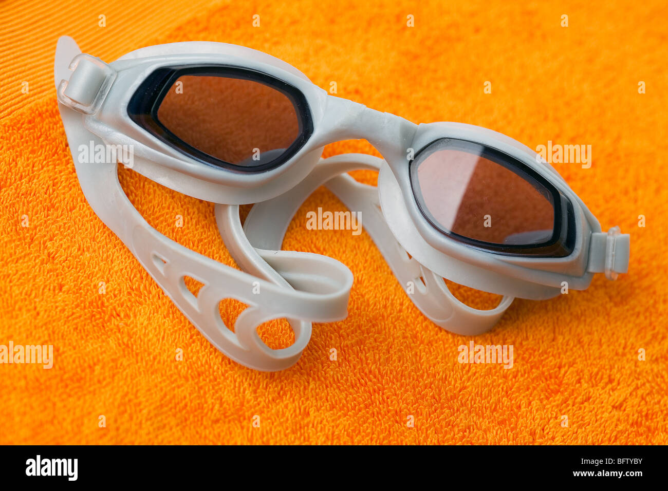 Schwimmen Brille auf orange Handtuch Stockfoto