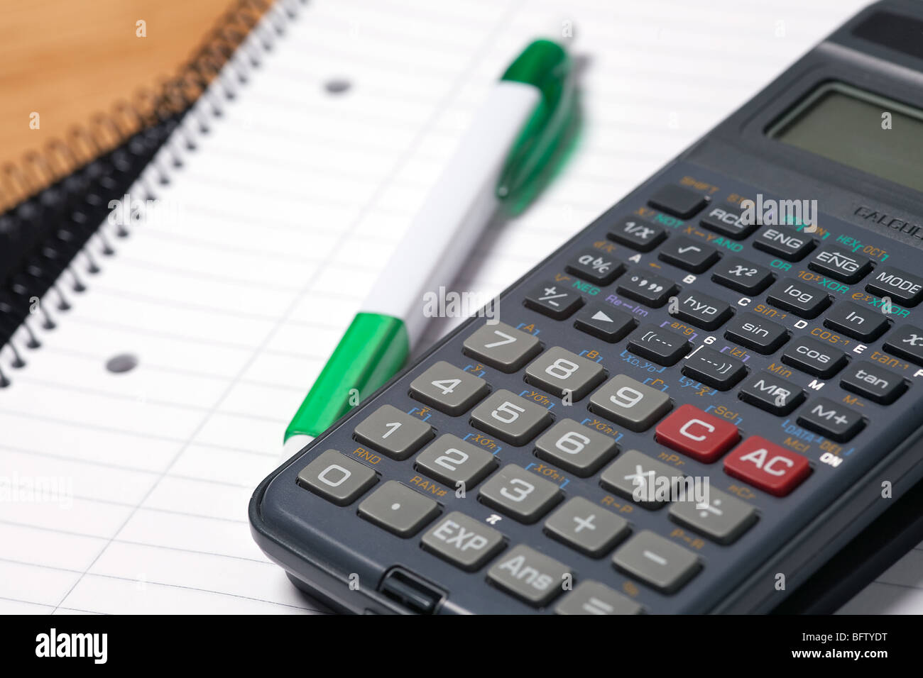 Taschenrechner, Kugelschreiber und Notizblock auf Tabelle Stockfoto
