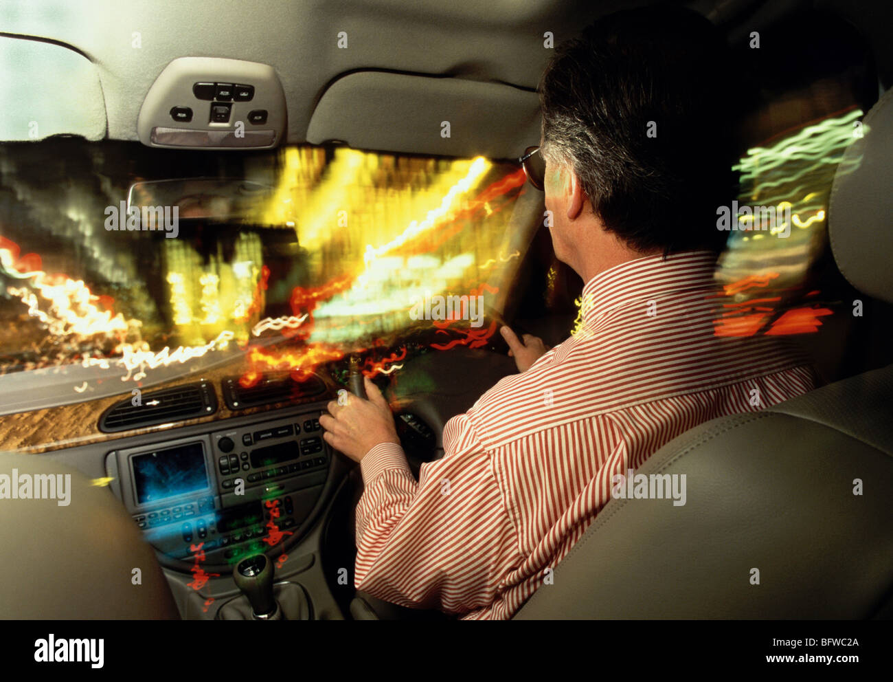 Geschäftsmann Jaguar durch Stadt bei Nacht zu fahren. Stockfoto