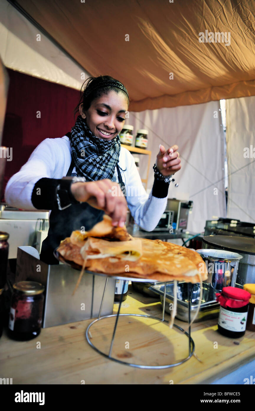 Paris, Frankreich, Weihnachtseinkäufe, Schwarze weibliche Teen, die am Stand Crepes kochen, traditioneller Markt, Street Food Vendor, nachts arbeiten, Jobs für Jugendliche Stockfoto