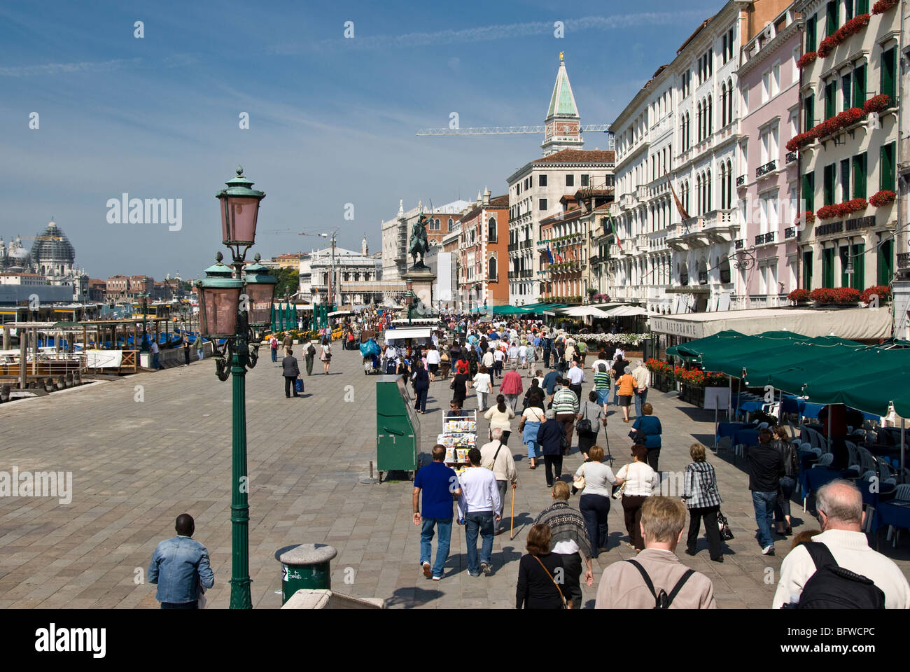 Massen zu Fuß entlang der Promenade in Venedig an einem sonnigen Tag. Stockfoto