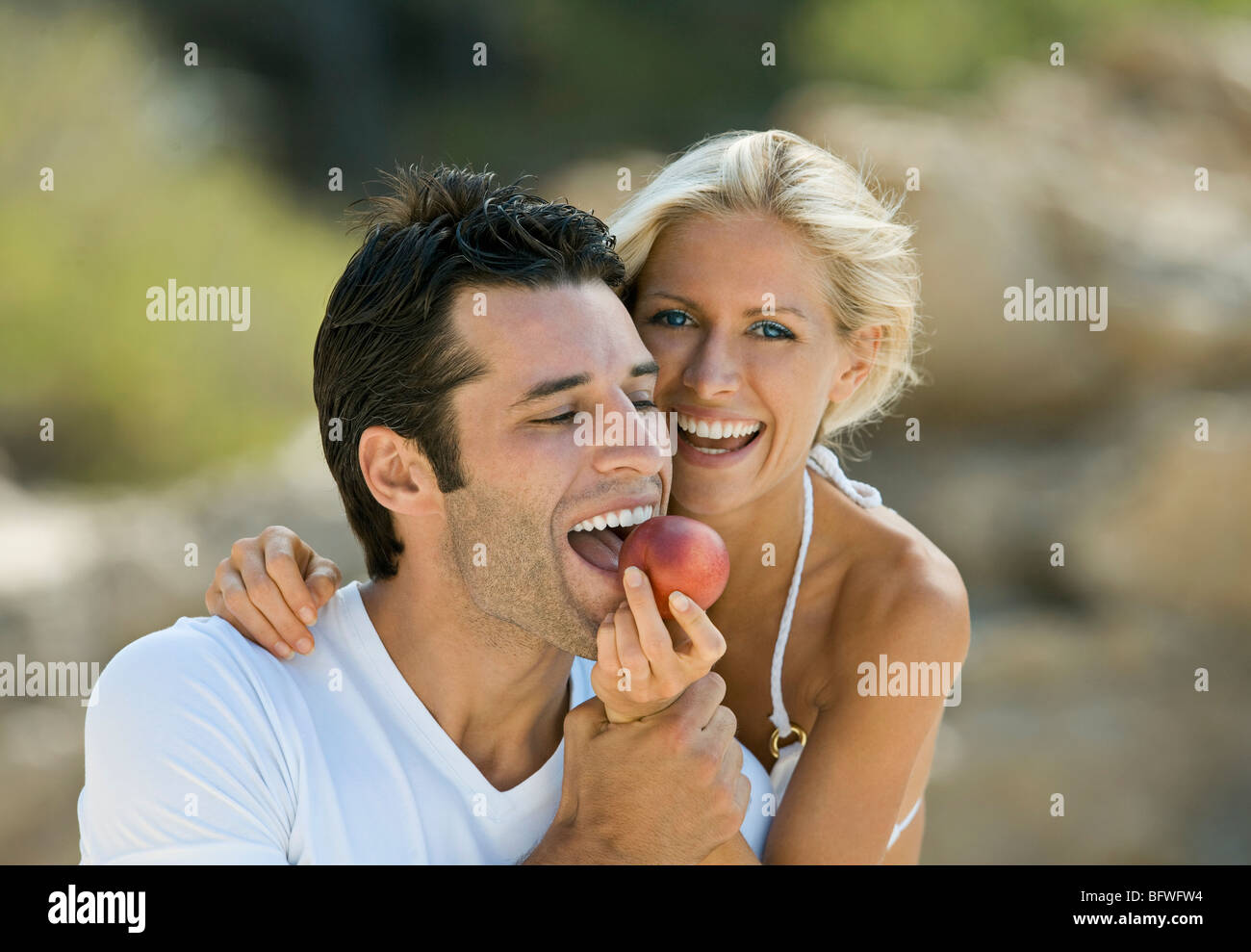 Ein Weibchen füttern einem Latein-Mann eine Nektarine Stockfoto