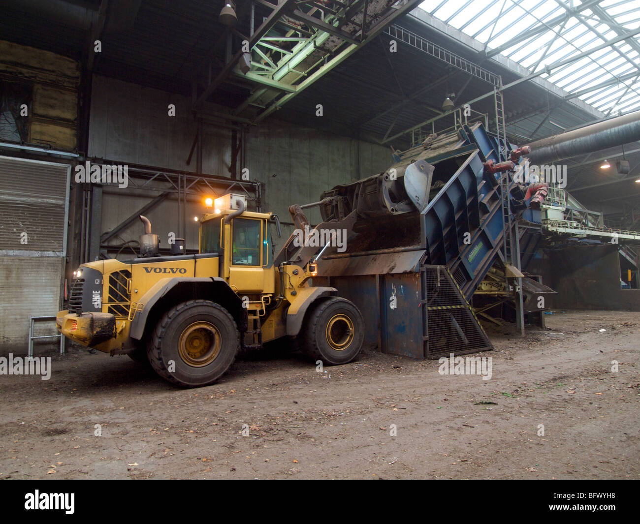 Großen Volvo dumping Last von organischen Müll in Shredder auf  Kompostierungsanlage Schaufeln Stockfotografie - Alamy