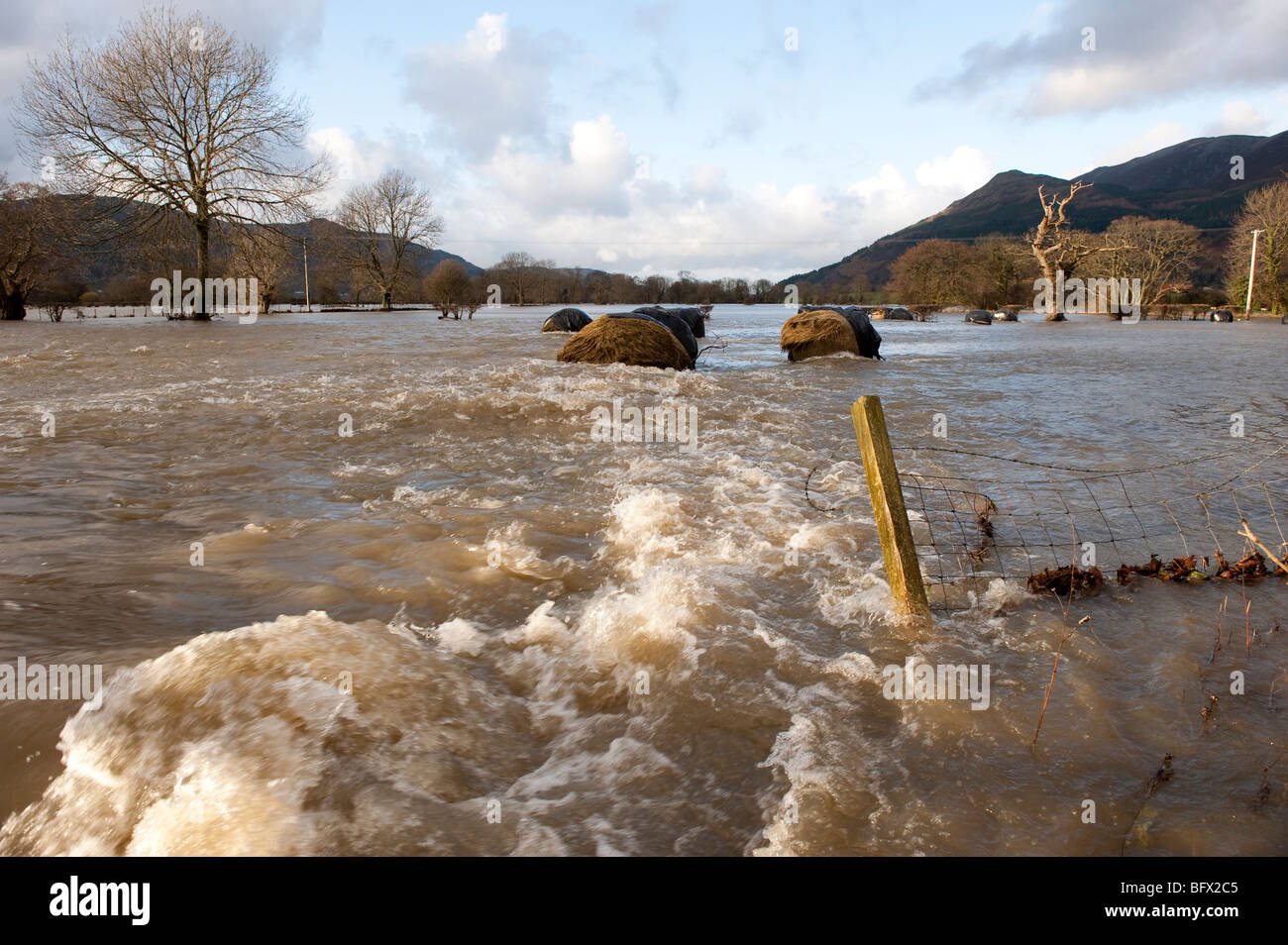 Überfluteten Ackerland zeigt Großballen und Zäune beschädigt Stockfoto