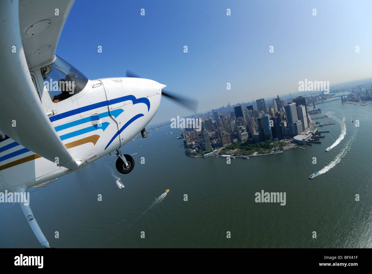 Eine leichte Flugzeug Cessna 172 fliegen über Lower Manhattan und Hudson River, New York City, USA Stockfoto