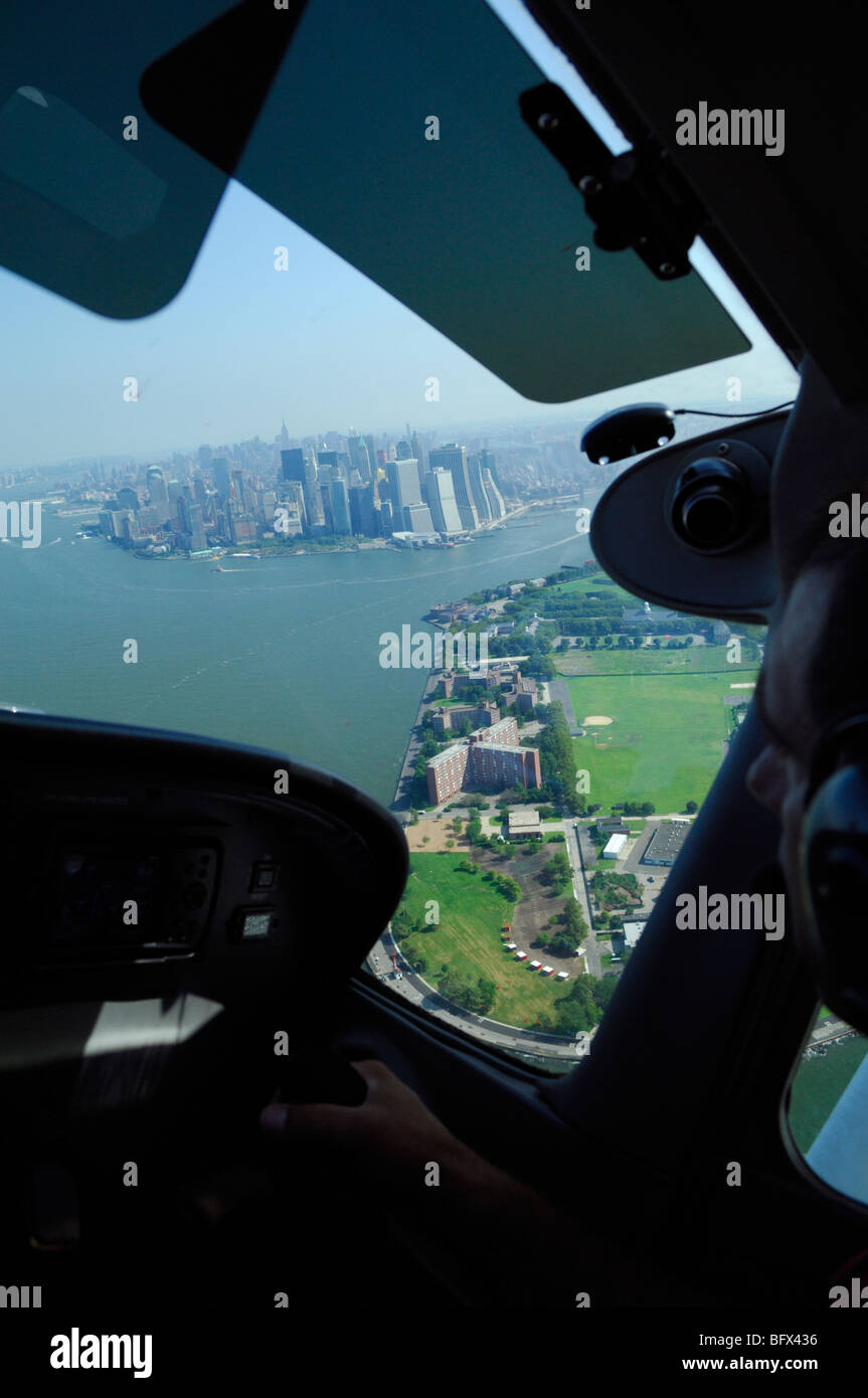Ein Pilot der Lichtebene Cessna 172 fliegen über Governors Island und Manhattan East River in New York City, USA Stockfoto