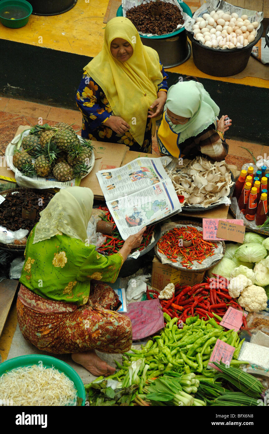 Drei malaiische oder malaysische Frauen diskutieren Wahlergebnisse veröffentlicht in der Zeitung, zentrale Gemüsemarkt, Kota Bahru, Buchladen Stockfoto