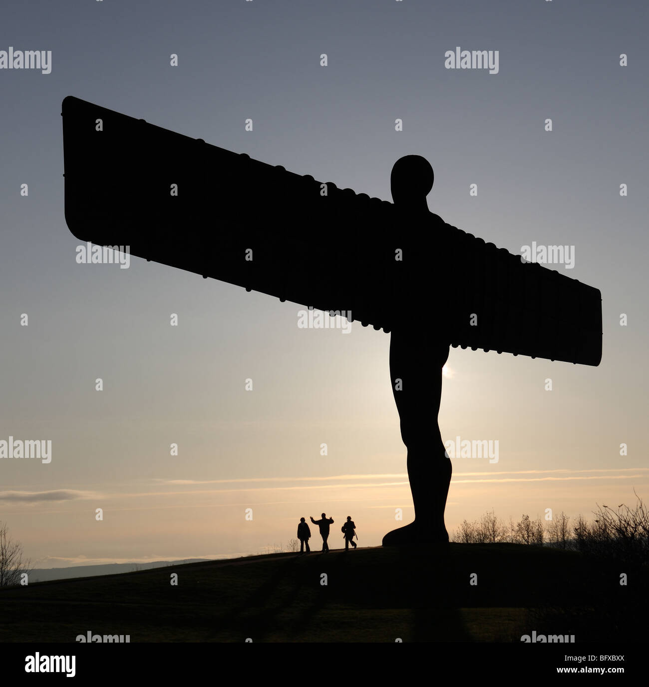 Der Engel des Nordens Skulptur von Anthony Gormley in Silhouette mit drei Bewunderer, Gateshead, England, Großbritannien Stockfoto