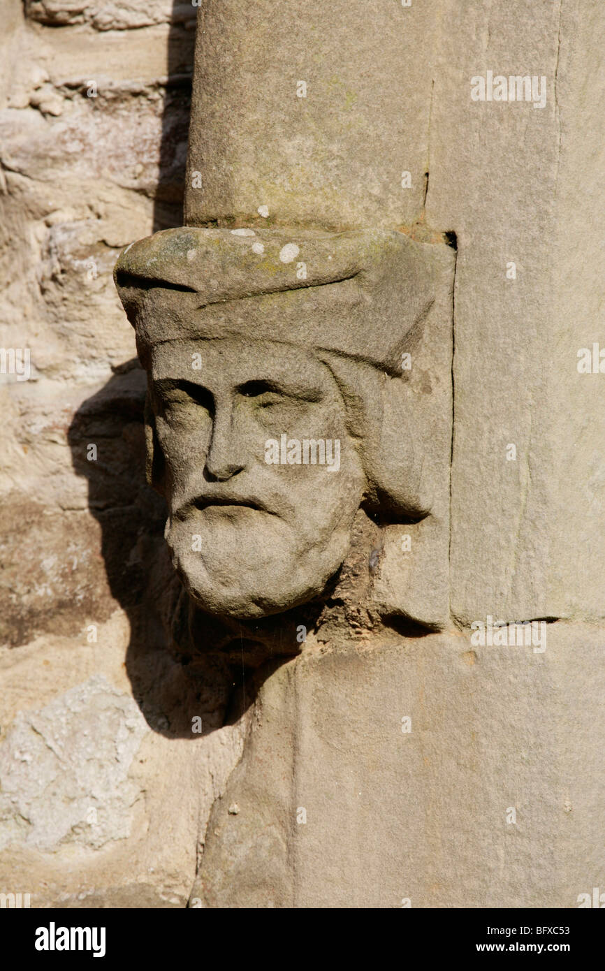 15. Jahrhundert Kirchenfenster, Headmould Halt in Form von einem Stein Skulptur Darstellung ein Männerkopf. Stockfoto