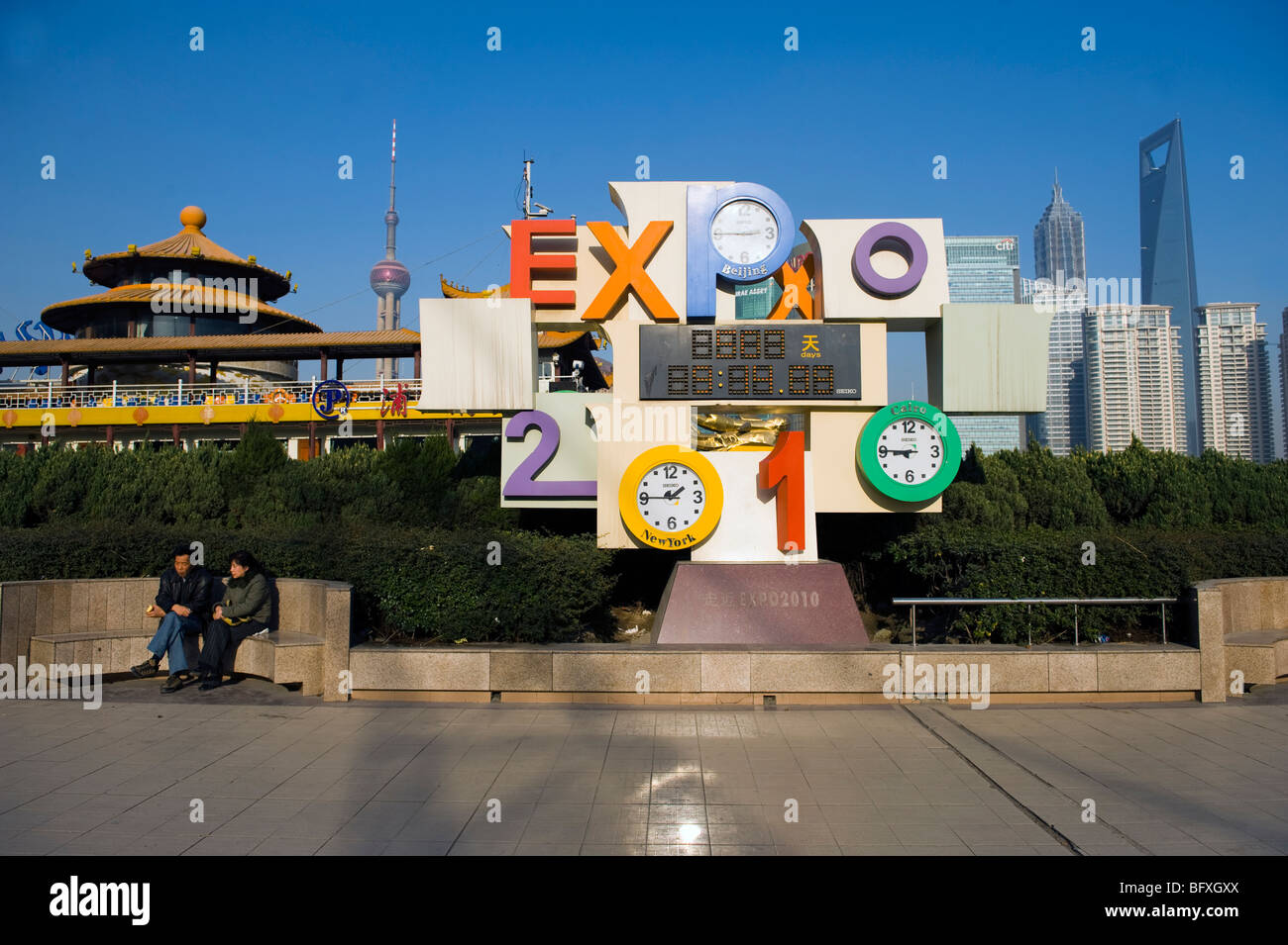 Ein paar der Chinesen sitzen in der Nähe der Shanghai Expo 2010 Logo an einem sonnigen Tag am Bund mit Skyline von Pudong einschließlich Orient Pearl Stockfoto