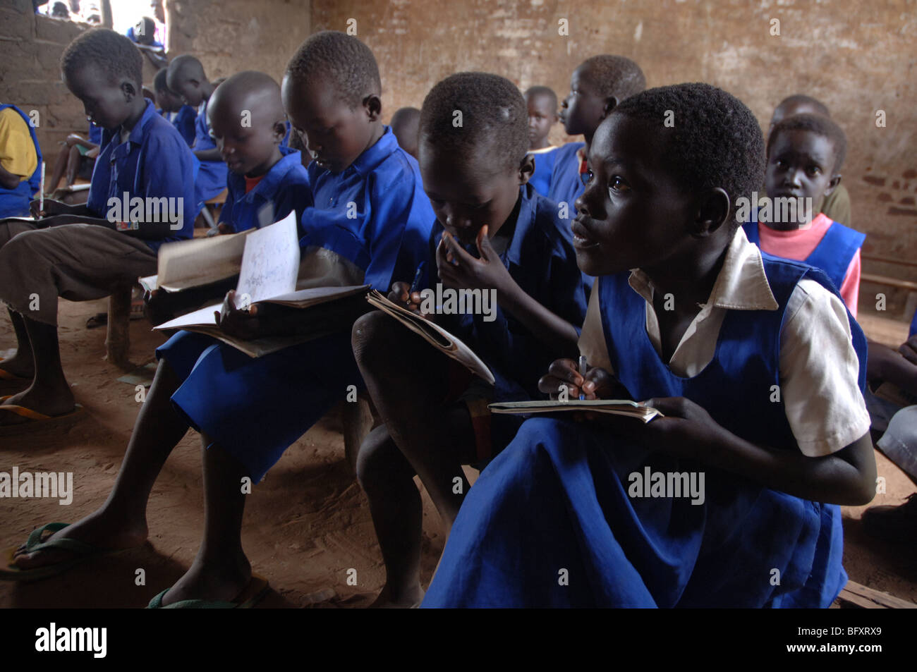 Schülerinnen und Schüler lernen in einer Schulklasse, die von Tausenden von Kugeln während des Krieges in Yei, Sudan 34 gezeichnet worden. Stockfoto