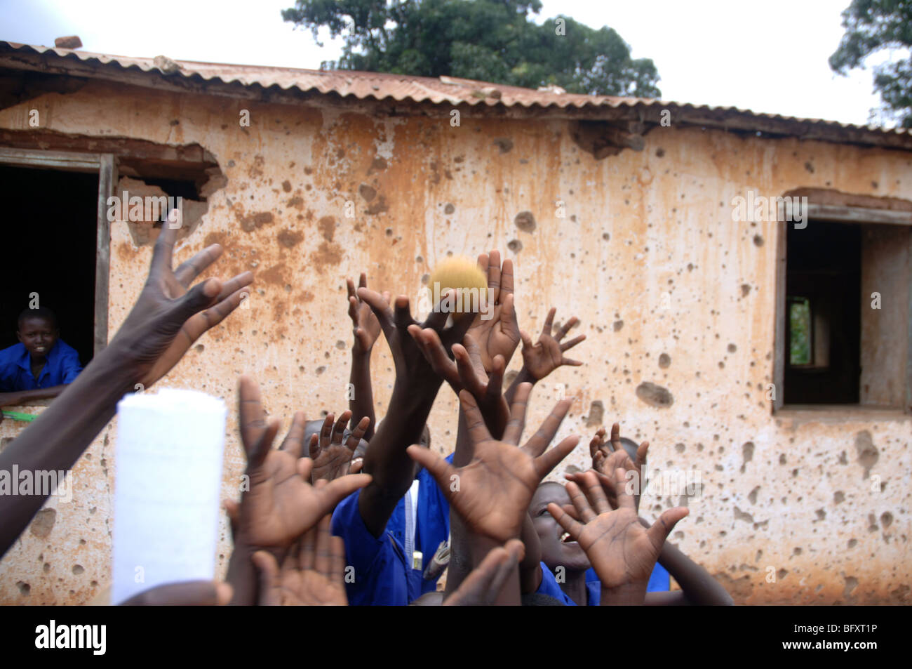 Schülerinnen und Schüler lernen in einer Schulklasse, die von Tausenden von Kugeln während des Krieges in Yei, Sudan 34 gezeichnet worden. Stockfoto