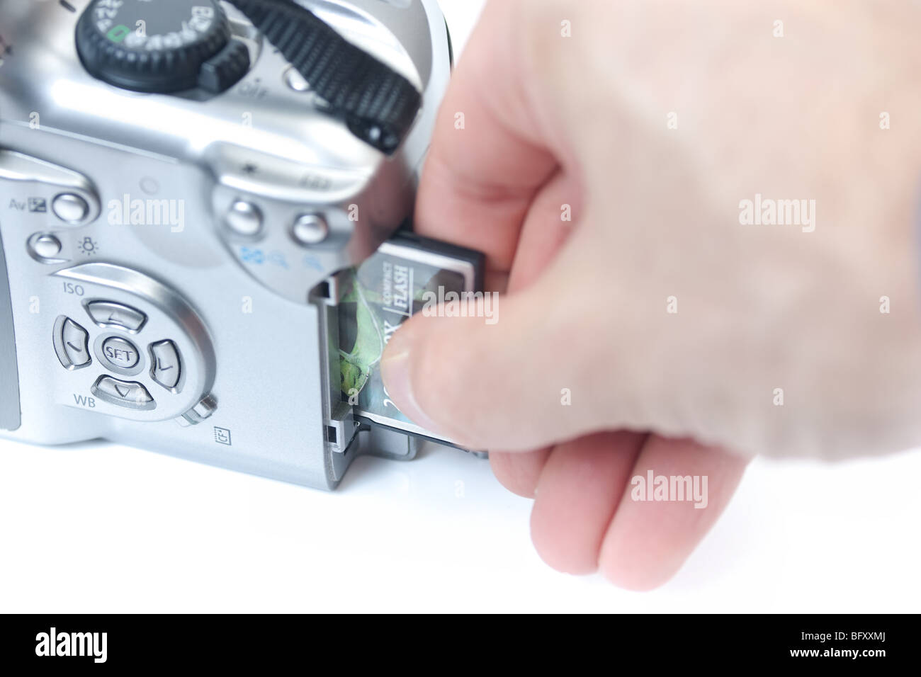 Eine Nahaufnahme einer Hand Einfügen einer compact flash Memory Card in eine digitale SLR-Kamera. Stockfoto
