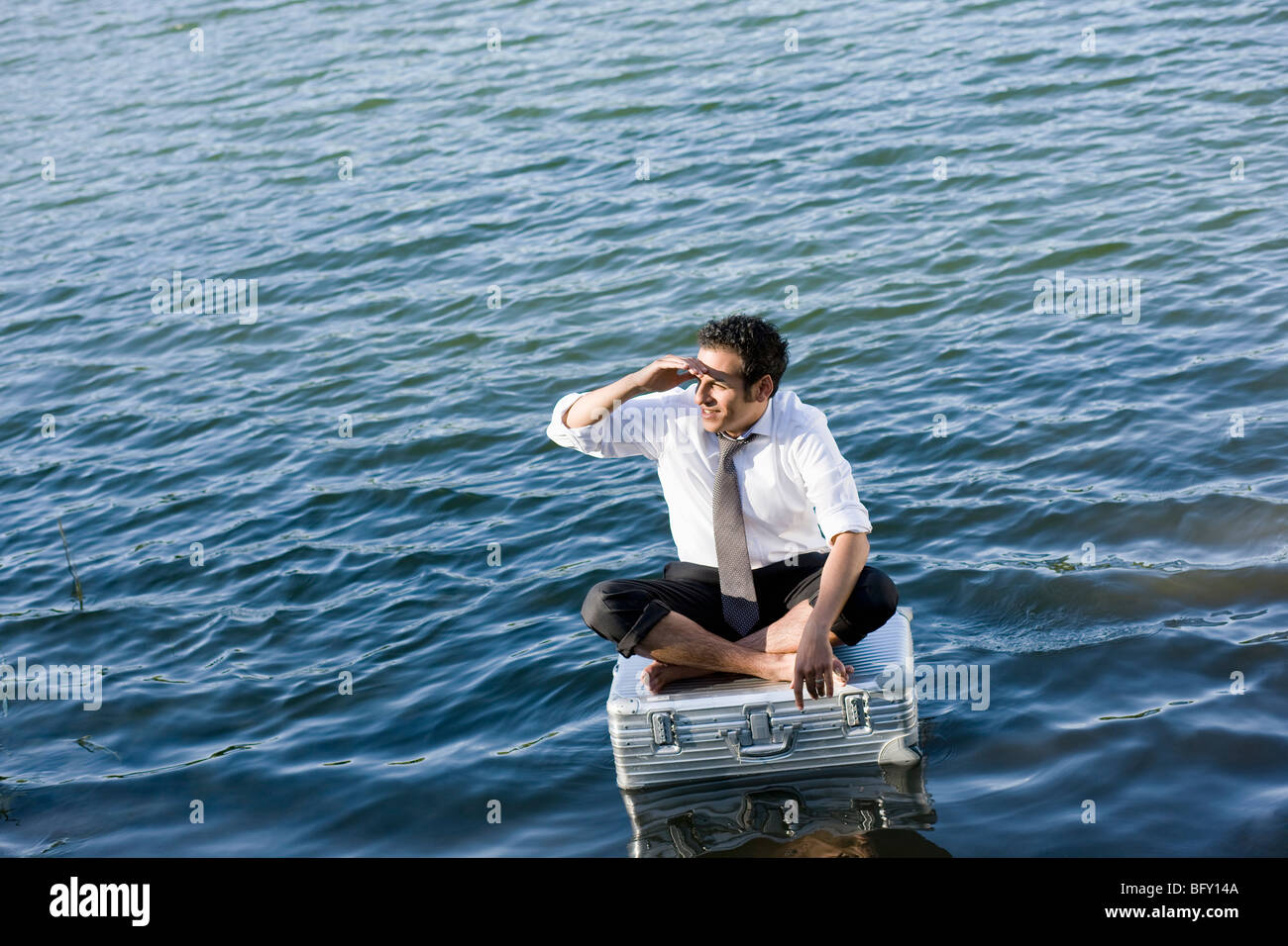 Geschäftsmann, sitzen auf schwimmenden Koffer Stockfoto