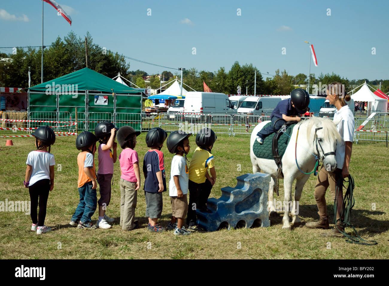In der jährlichen Gascogne Expo Landwirtschaftsmesse in Auch Line-up kleine Kindern, abwechselnd im sitzen auf einem pony Stockfoto