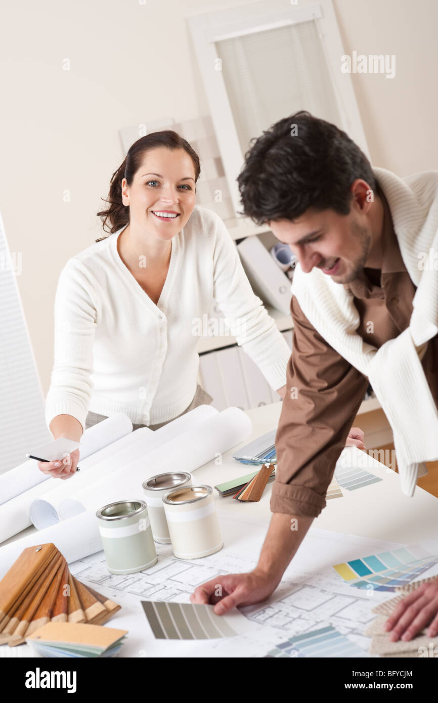 Zwei junge erfolgreiche Innenarchitektin arbeitet im Büro mit Farbfeld und Dose Farbe Stockfoto