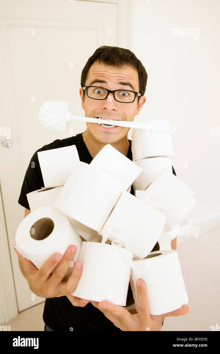 Mann mit WC-Bürste und Toilettenpapierrollen Stockfoto