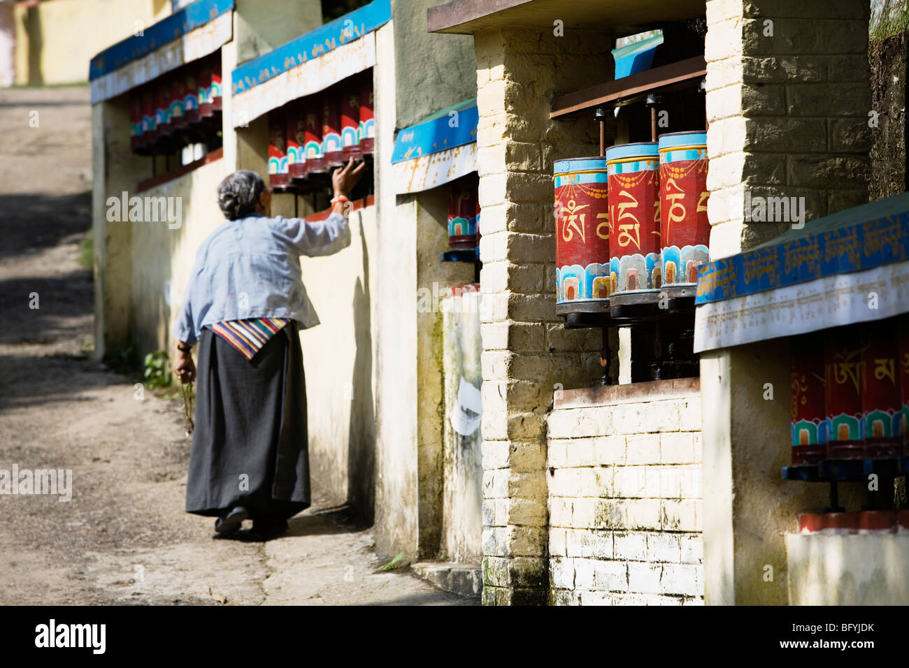 Tibetische Pilger drehen Gebetsmühlen und machen eine Kora (Seremonial Kreis) rund um die Residenz des Dalai Lama in Dharamsala, Indien. Stockfoto